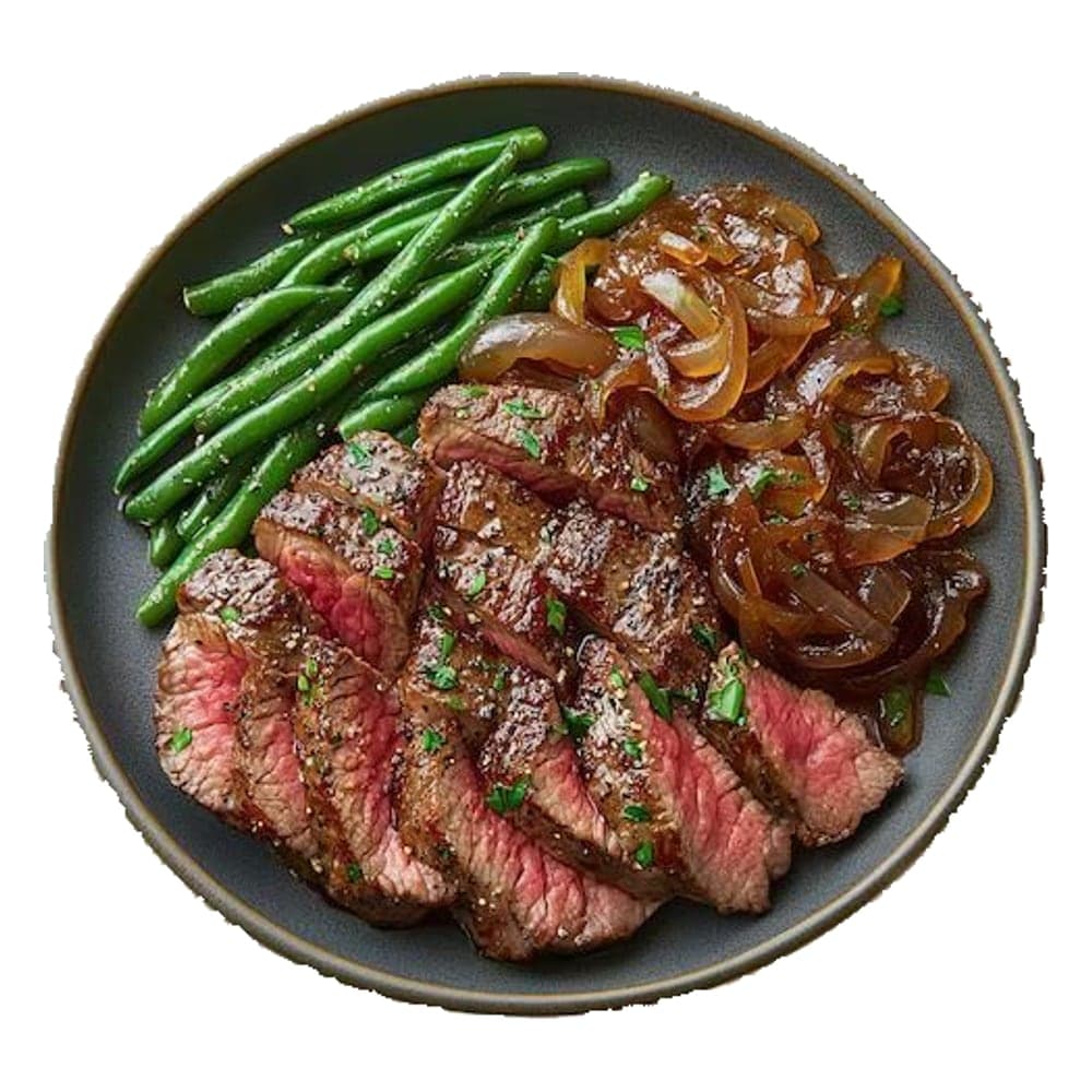 Sliced medium steak with green beans and caramelized onions